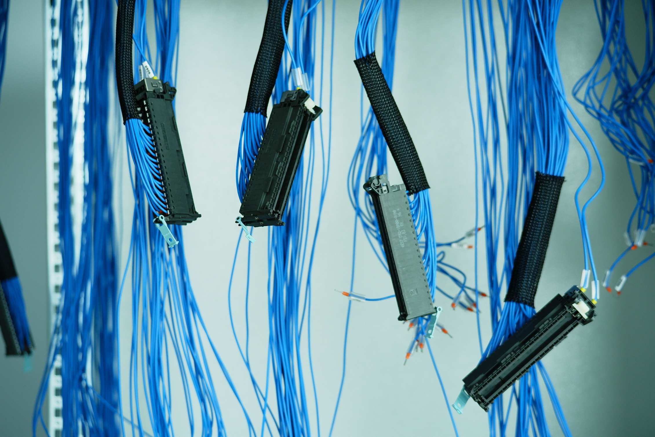 Rows of server racks in a data hall with ethernet cables in a data center