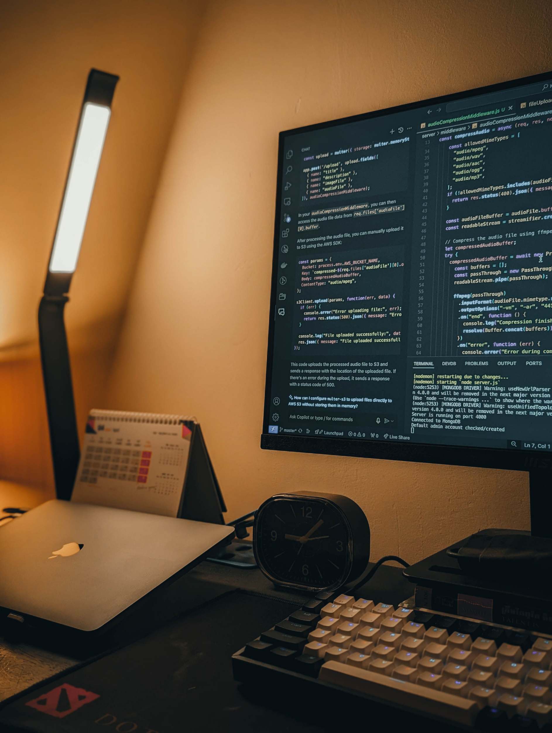 Developer workstation with code on screen in a home office with coding monitor and laptop